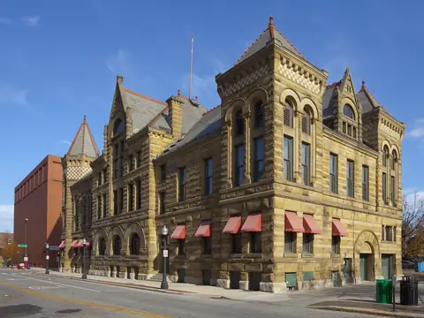 The sandstone Old City Hall on a downtown Fort Wayne street under a blue sky