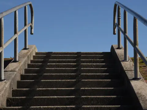 Outdoor concrete steps with a metal handrail