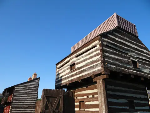 A log blockhouse at Historic Fort Wayne under a clear blue sky
