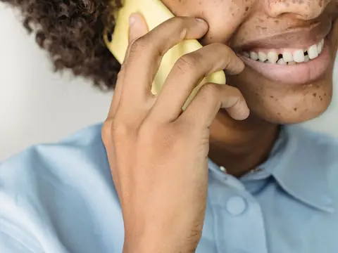 A smiling person talking on a phone