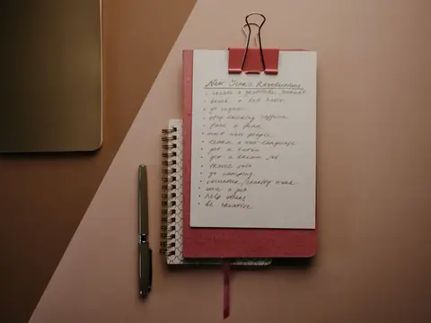 A notepad with a short list of questions beside a pen