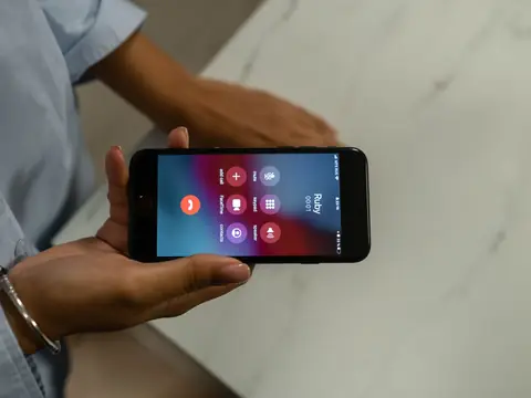 A hand holding a phone with a call in progress