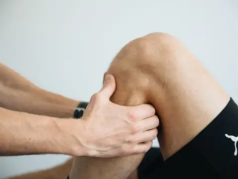 A physical therapist's hands working on a knee