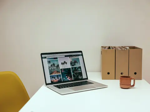 A laptop and paper file holders on a white desk